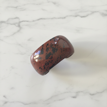 Load image into Gallery viewer, Mahogany jasper cuff bracelet flat lay on marble