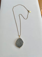 Load image into Gallery viewer, Full silver-gray druzy pendant necklace showing the fine textured chain, clasp, and oval end tag