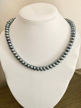 Load image into Gallery viewer, A silver grey pearl necklace with a streamlined finish displayed on a mannequin bust.