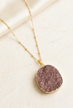 Load image into Gallery viewer, Brown-purple druzy necklace in an angled ivory editorial setting
