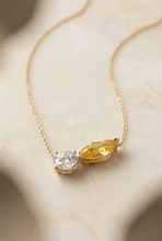Load image into Gallery viewer, Yellow sapphire and diamond necklace on warm ivory stone
